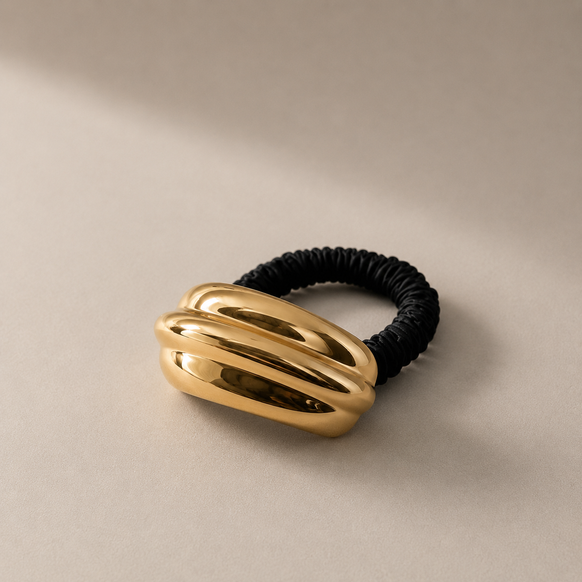 Gioiello per capelli con elastico in seta e dettaglio dorato moderno.